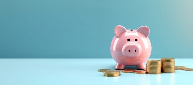 Pink pig piggy bank next to a stack of gold coins, isolated on blue background. Investment success,