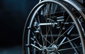 Detail of a wheelchair wheel with a dark background